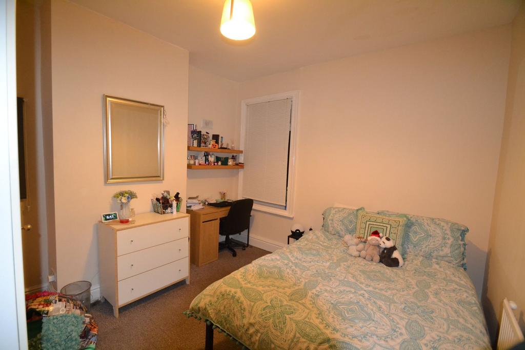 A cozy double bedroom featuring a large bed dec...