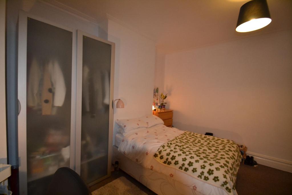 A cozy bedroom featuring a single bed with flor...