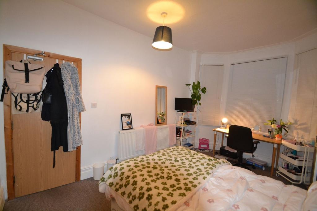 A cozy bedroom featuring a double bed with a pa...