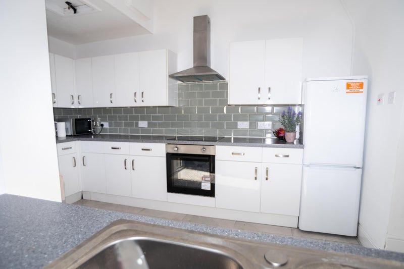 Bright modern kitchen with white cabinetry, int...