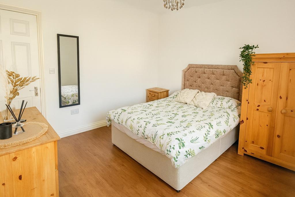 Bright and cozy master bedroom featuring a comf...