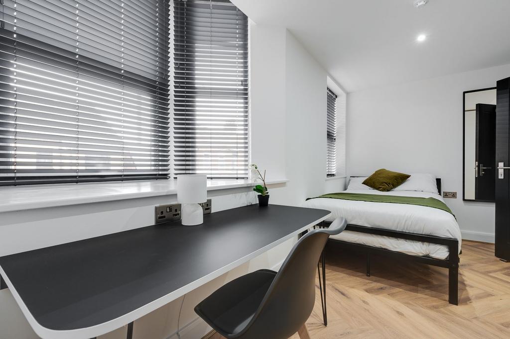 A bright, minimalist bedroom featuring a neatly...