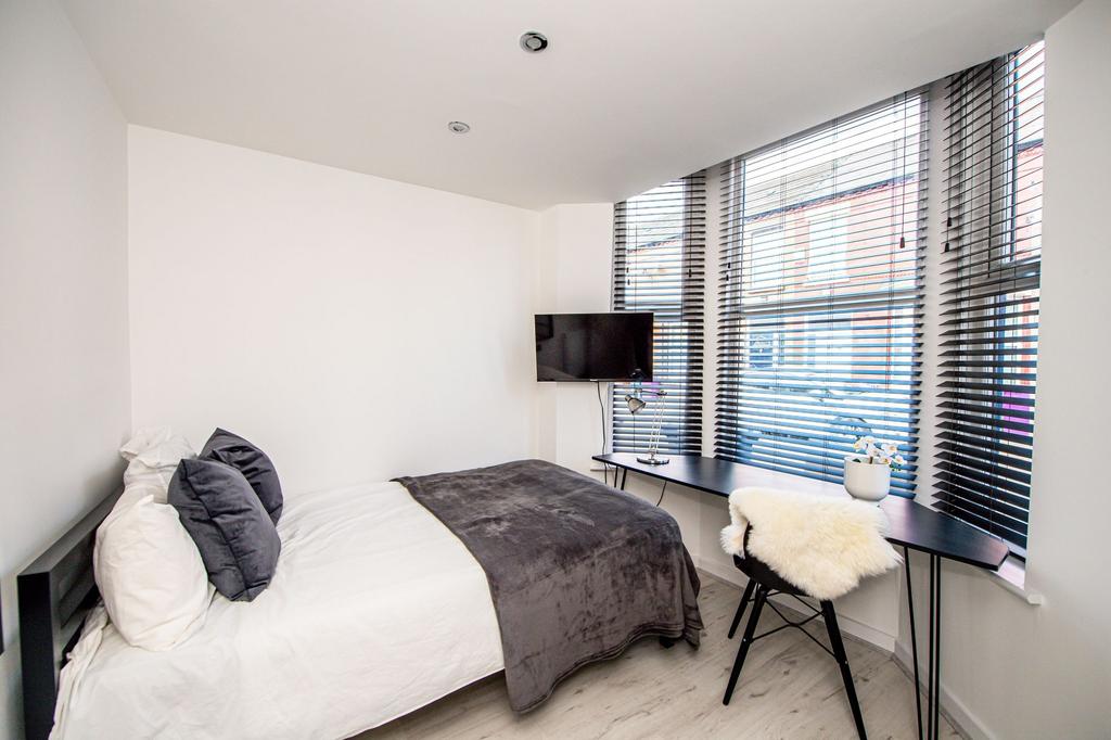 Bright and modern master bedroom featuring a sp...