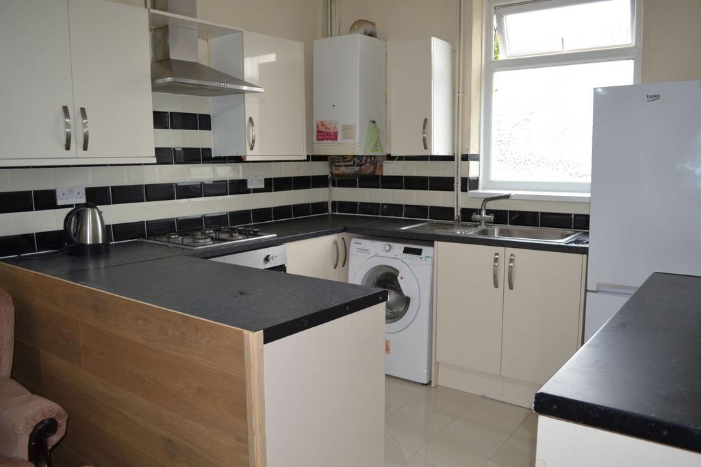 Bright, modern kitchen with white cabinetry, bl...