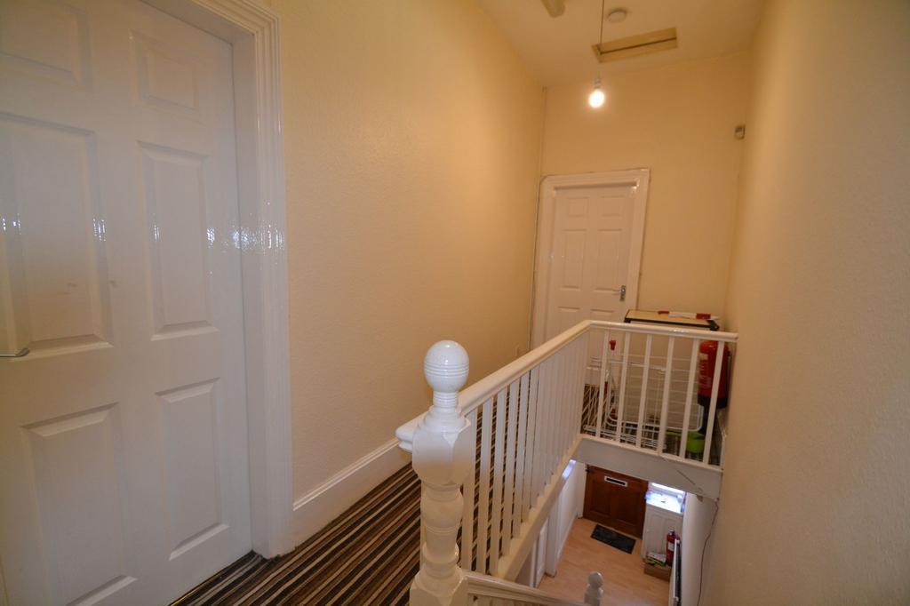 Bright upper landing with a painted white balus...