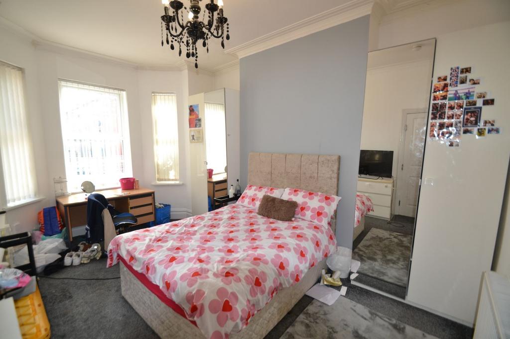 A cozy bedroom featuring a double bed with a co...