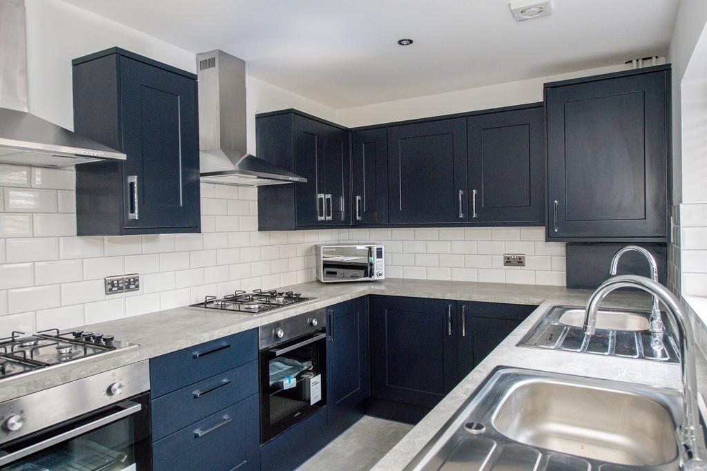 Modern U-shaped kitchen with dark cabinetry, st...