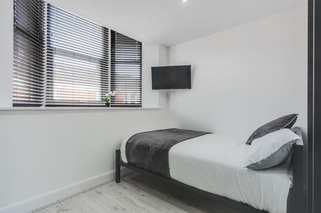 Modern, tidy single bedroom featuring a comfort...