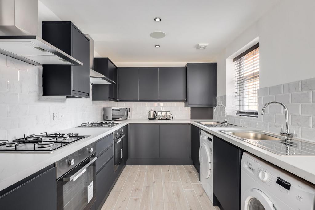 Modern kitchen with sleek dark cabinets, stainl...