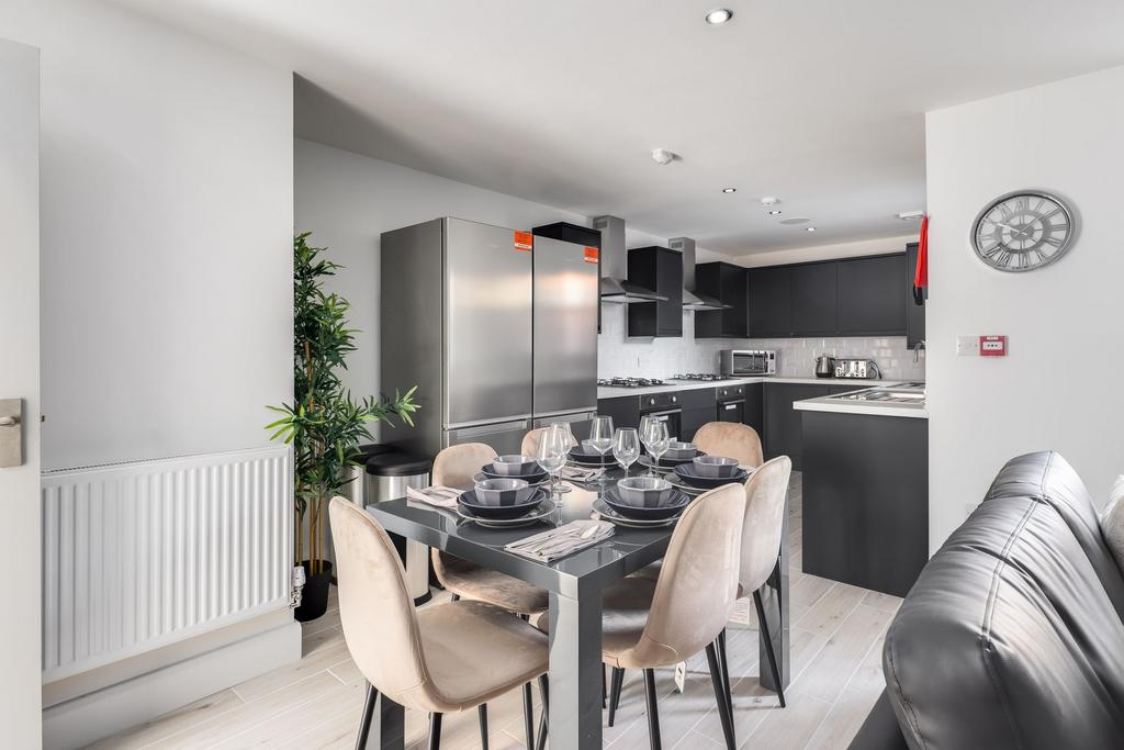 Modern kitchen with sleek black cabinetry, stai...