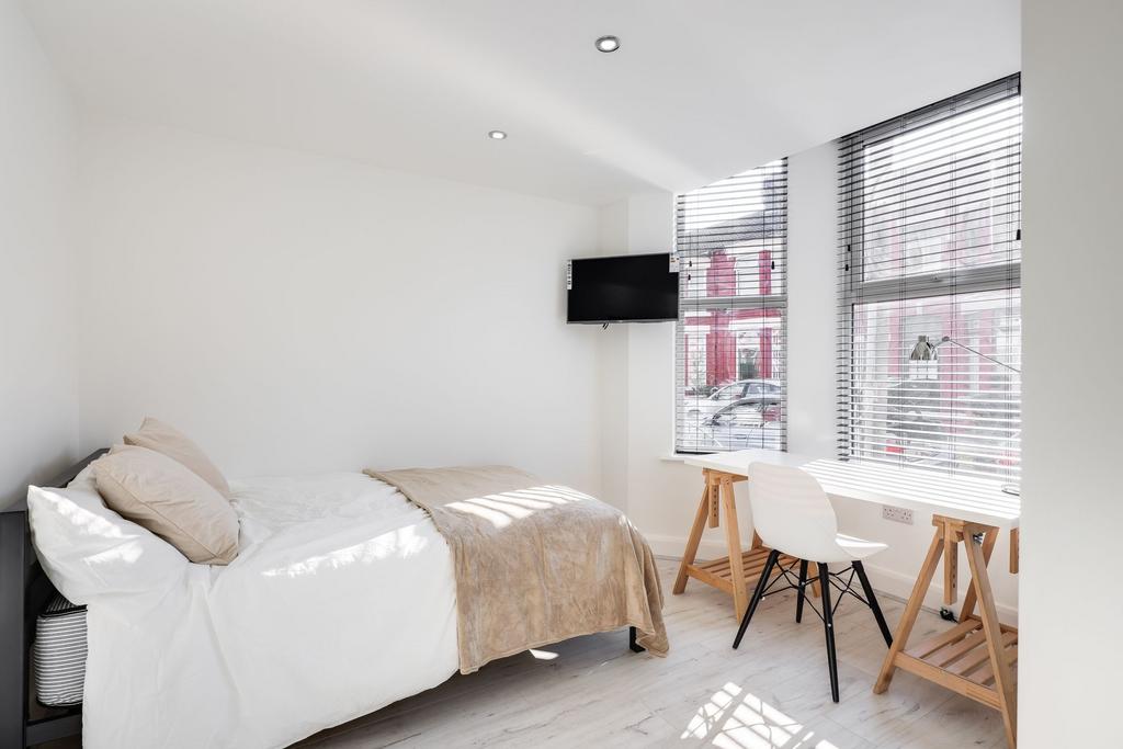 Bright and airy bedroom featuring a clean, mini...