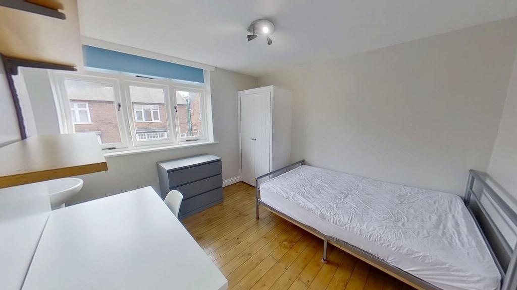 Bright, neatly furnished single bedroom with a ...
