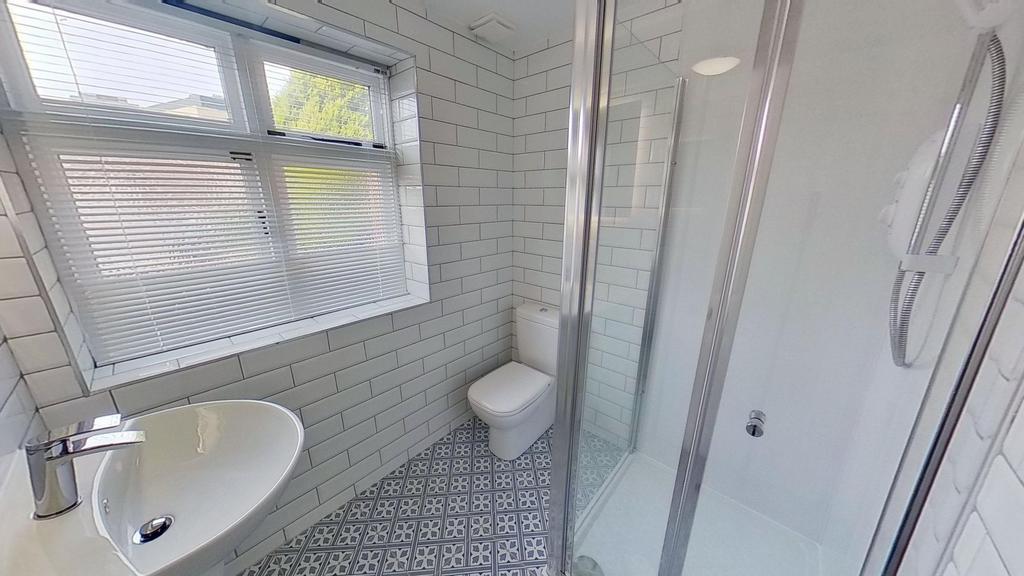 Bright, modern bathroom with patterned floor ti...