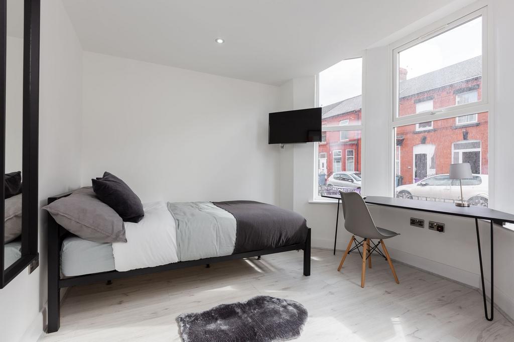 A bright and modern single bedroom featuring a ...