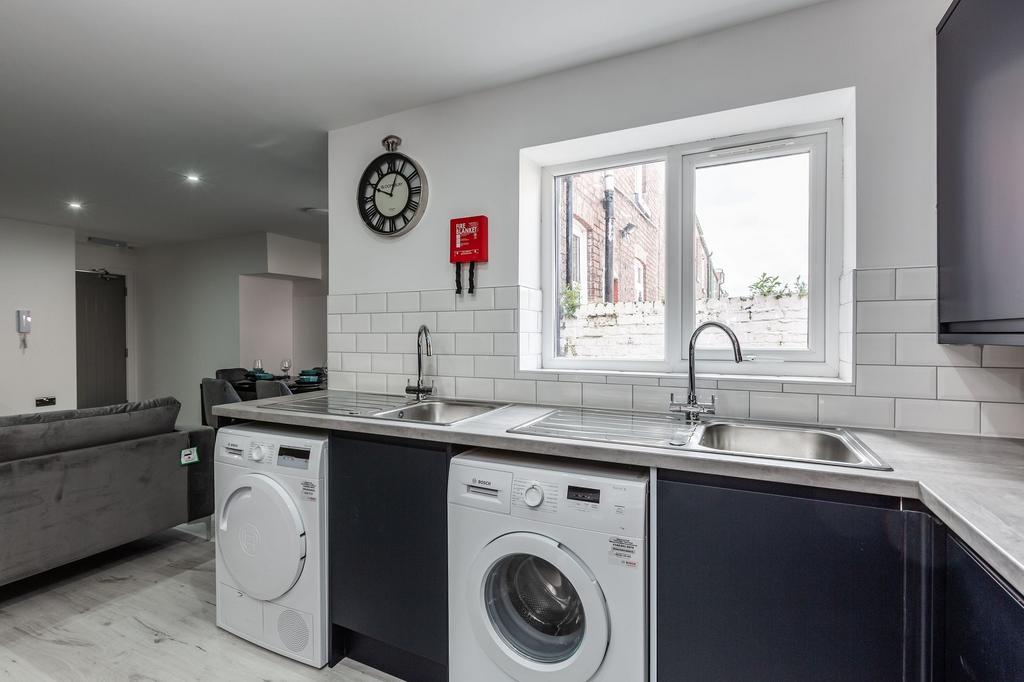 Modern kitchen with dual sinks, large window pr...