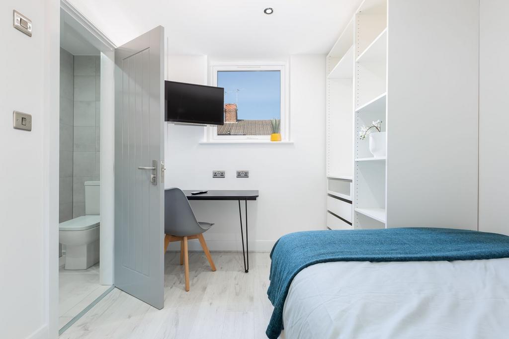 Bright and modern bedroom featuring a comfortab...