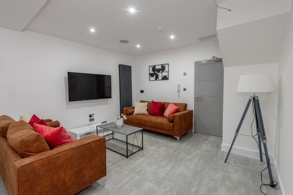 A spacious, modern living room featuring two co...