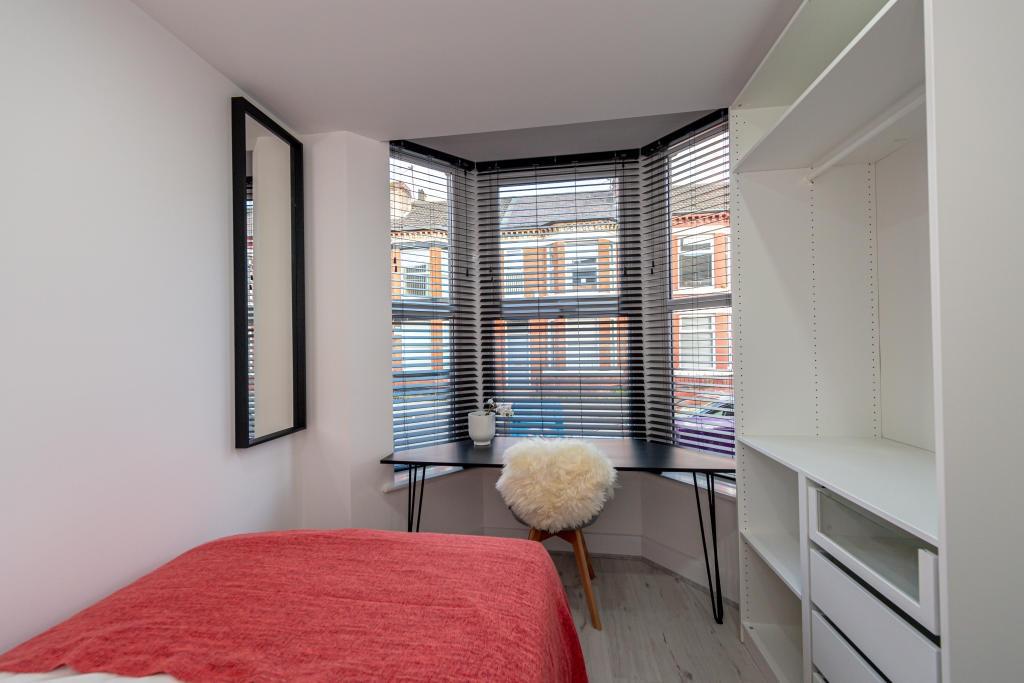 A bright and inviting bedroom featuring a large...