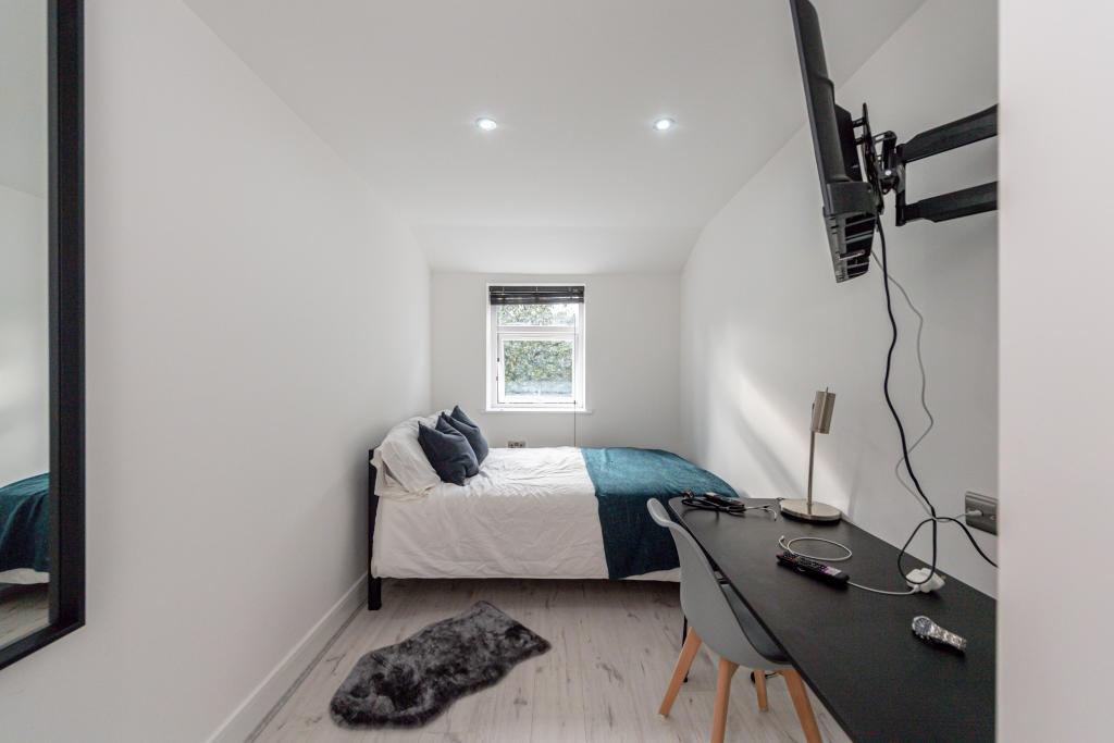 A well-lit, modern double bedroom featuring a c...