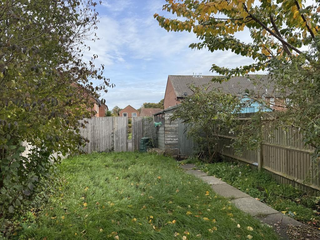 Garden with wooden shed and fenced boundary
