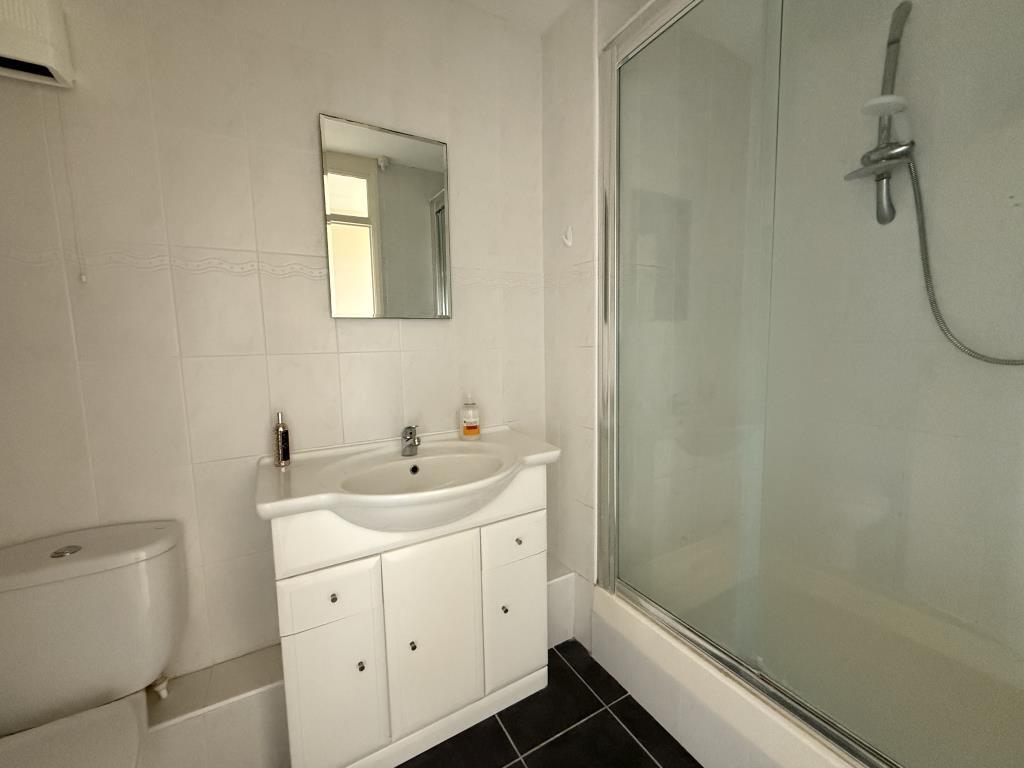 Bathroom with shower cubicle and white suite