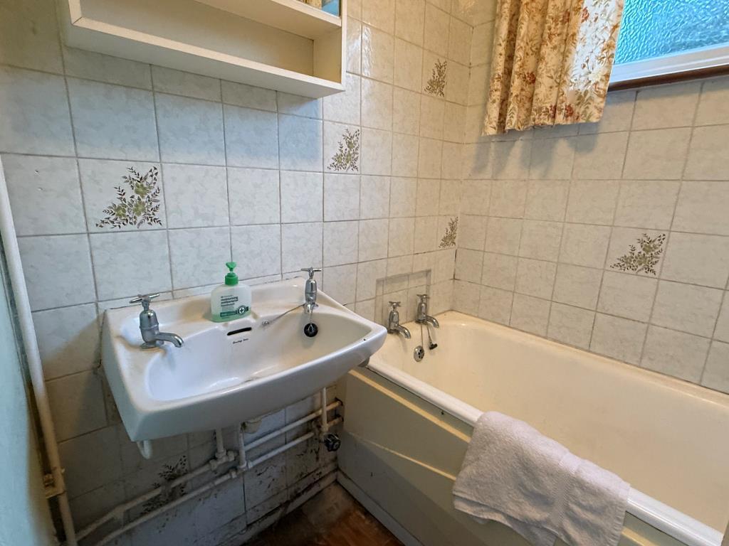 Tiled bathroom with sink and bath