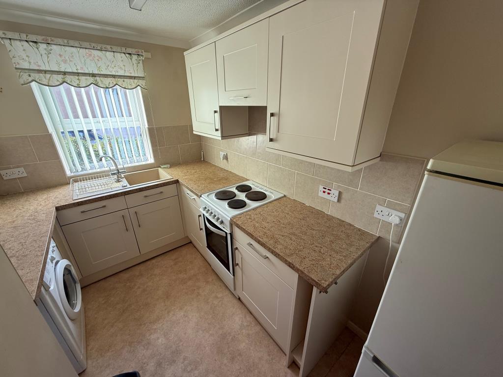 Kitchen with fitted units and window