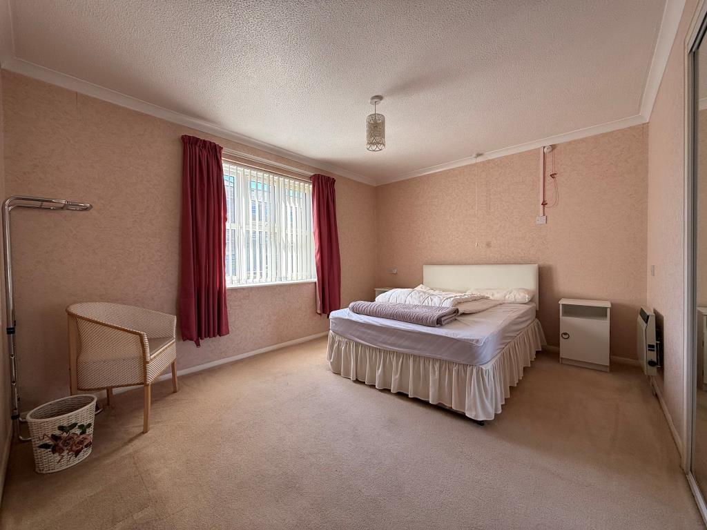 Main bedroom with fitted wardrobe and window
