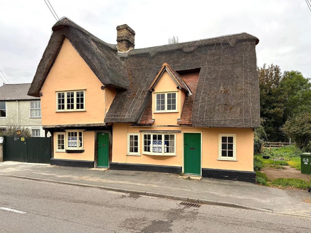 Front shot showing view from road of thatched cott