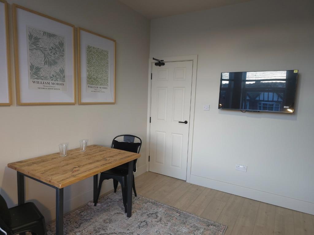 Bright, simply furnished living area with a wal...