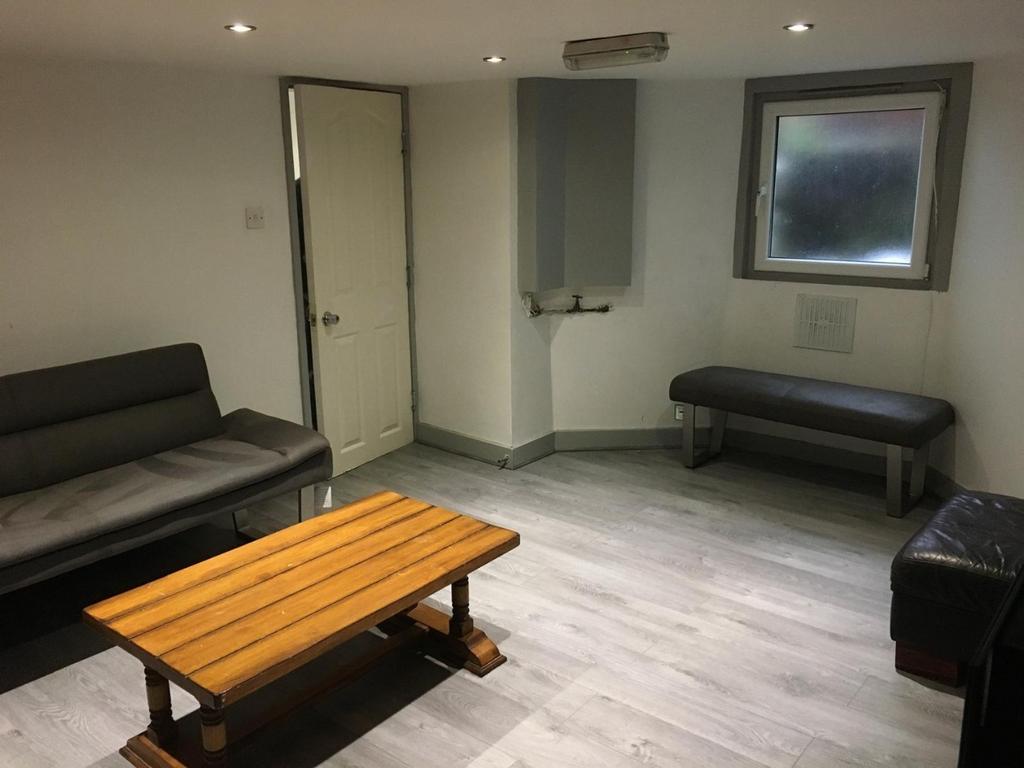 Bright, modern communal lounge with pale wood-e...