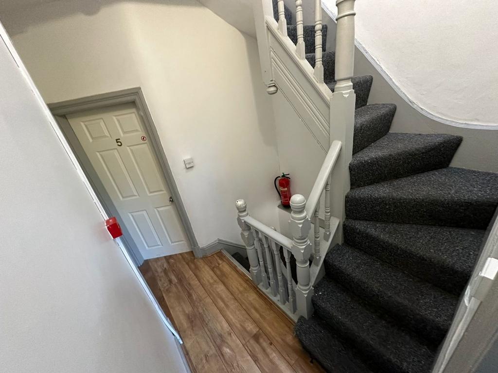 Bright, freshly painted entrance with a carpete...