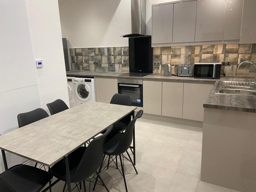 Modern open-plan kitchen with integrated applia...