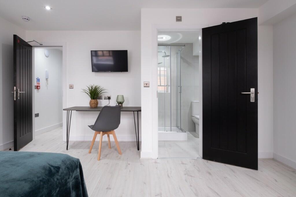 Bright and modern master bedroom featuring a co...