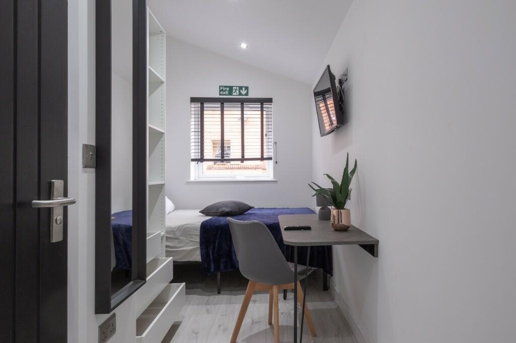 A neat and modern single bedroom featuring a co...
