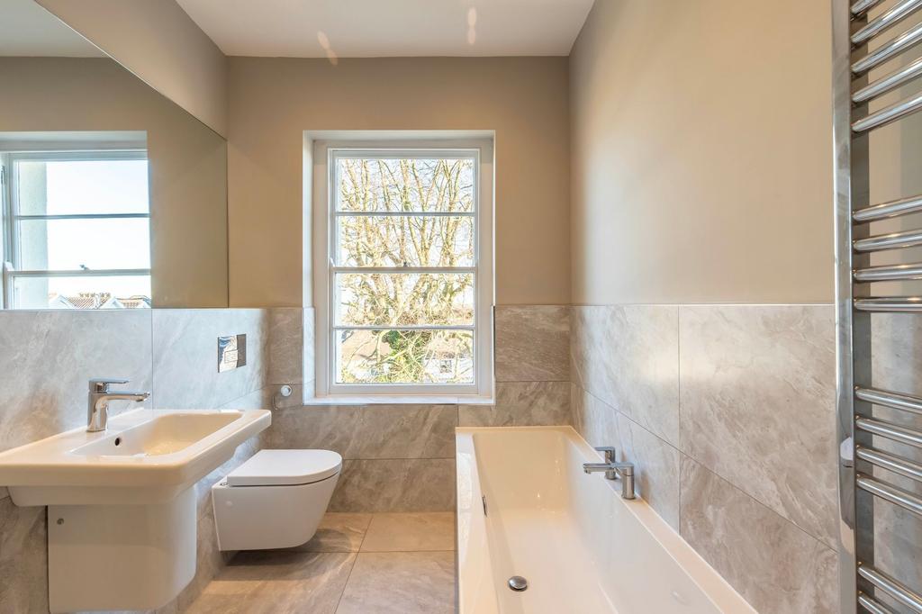 Bright, modern bathroom with a full-size bathtu...