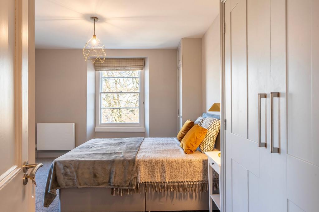 Bright, neatly staged double bedroom with a com...