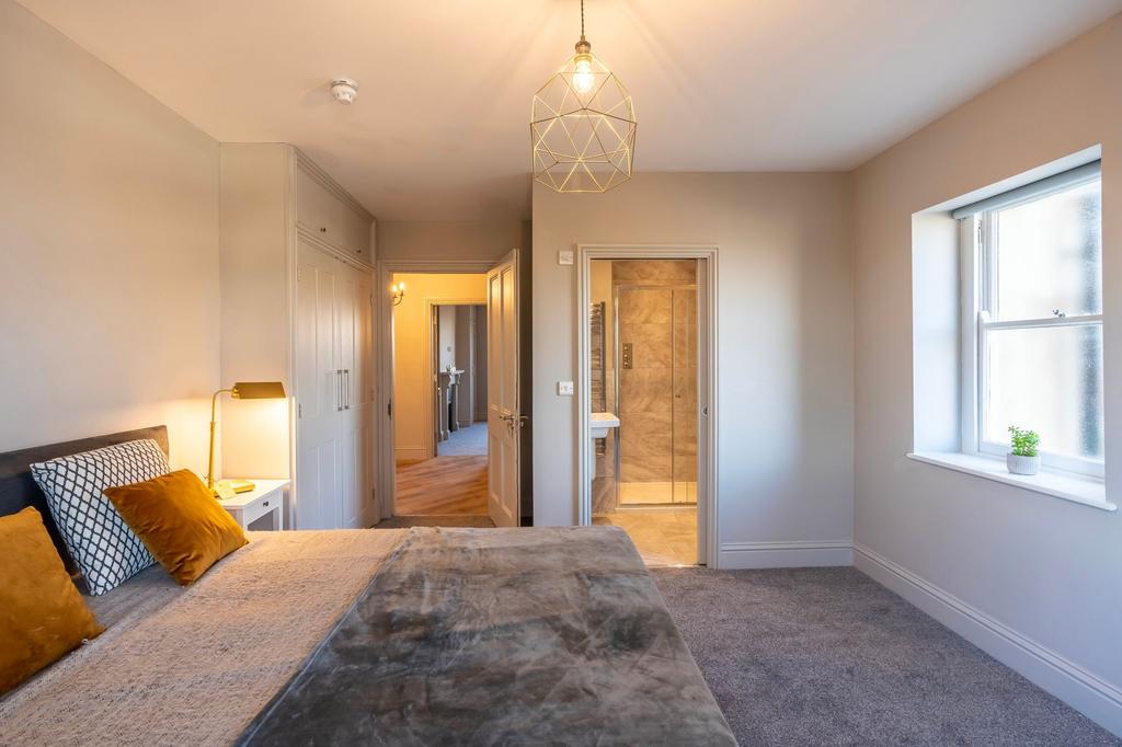 Bright, well-styled master bedroom with a comfo...