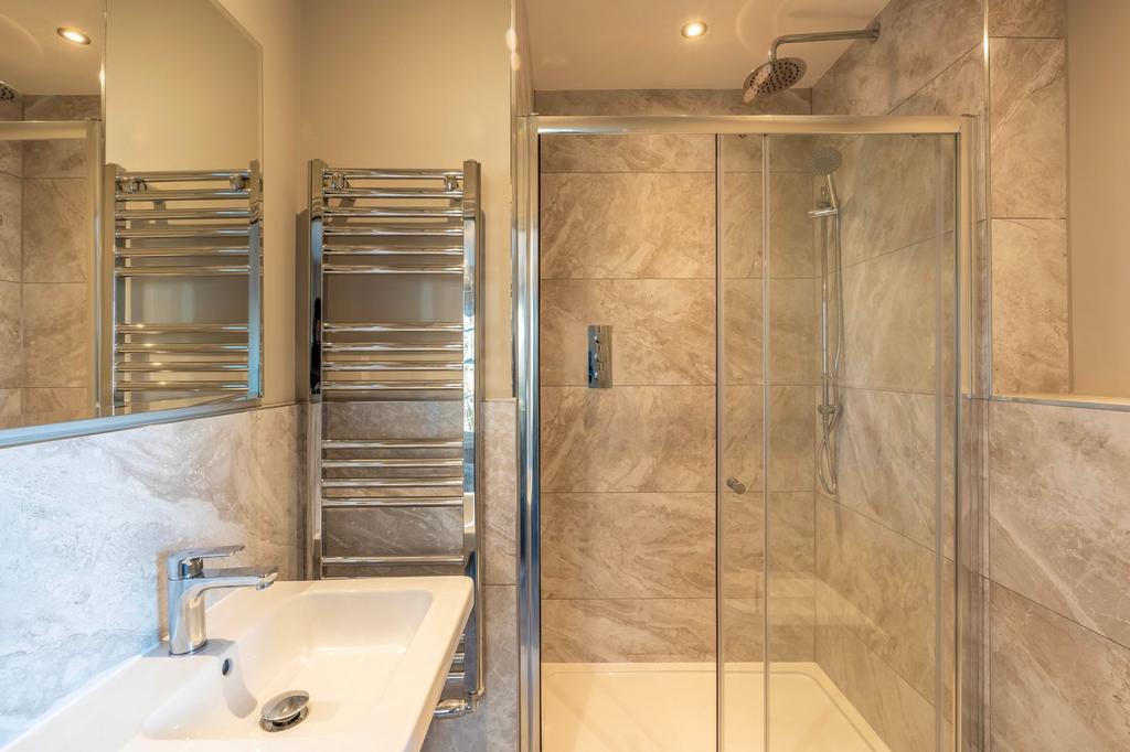 Modern en-suite bathroom with a walk-in shower,...
