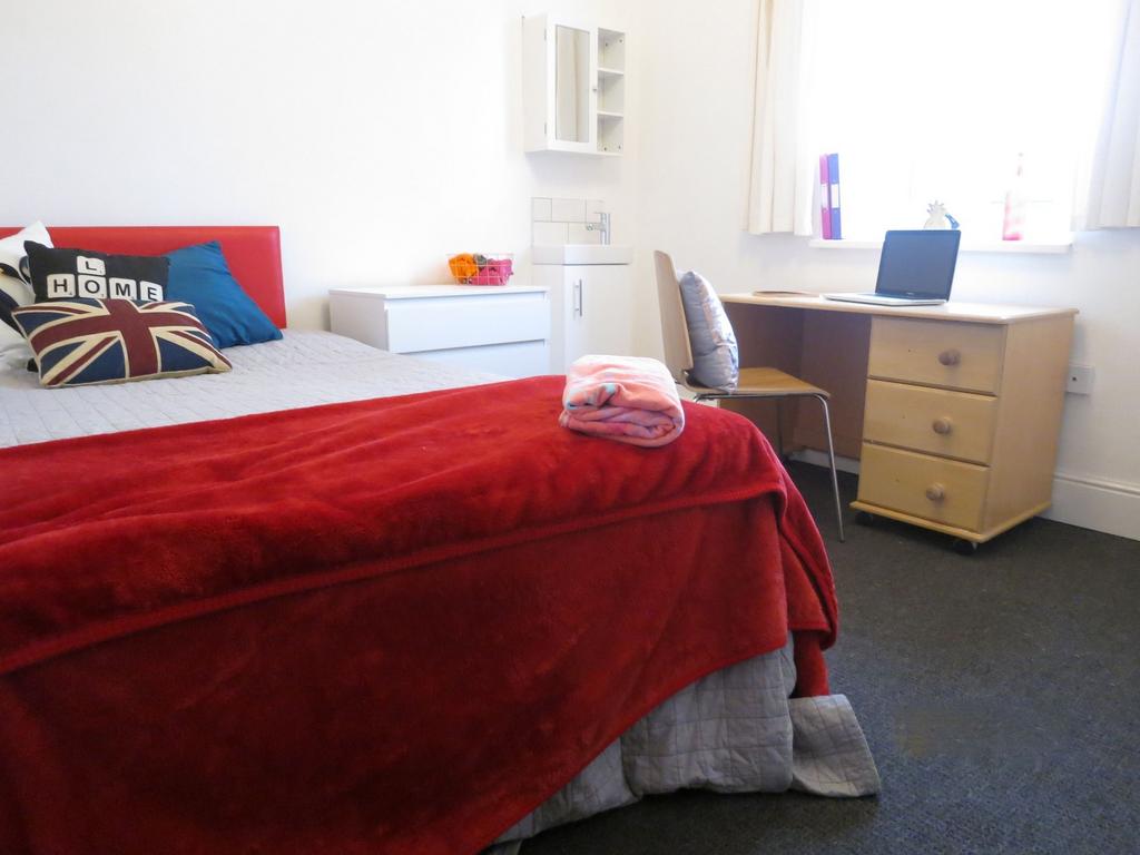 Bright, neatly arranged bedroom with a comforta...