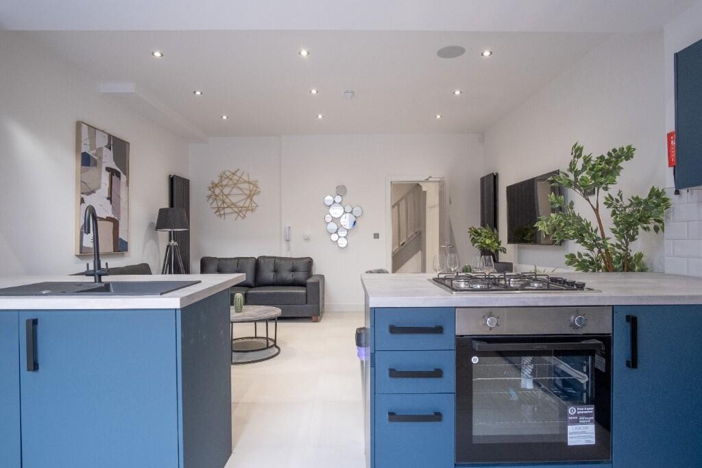 Modern, well-lit kitchen with sleek blue cabine...