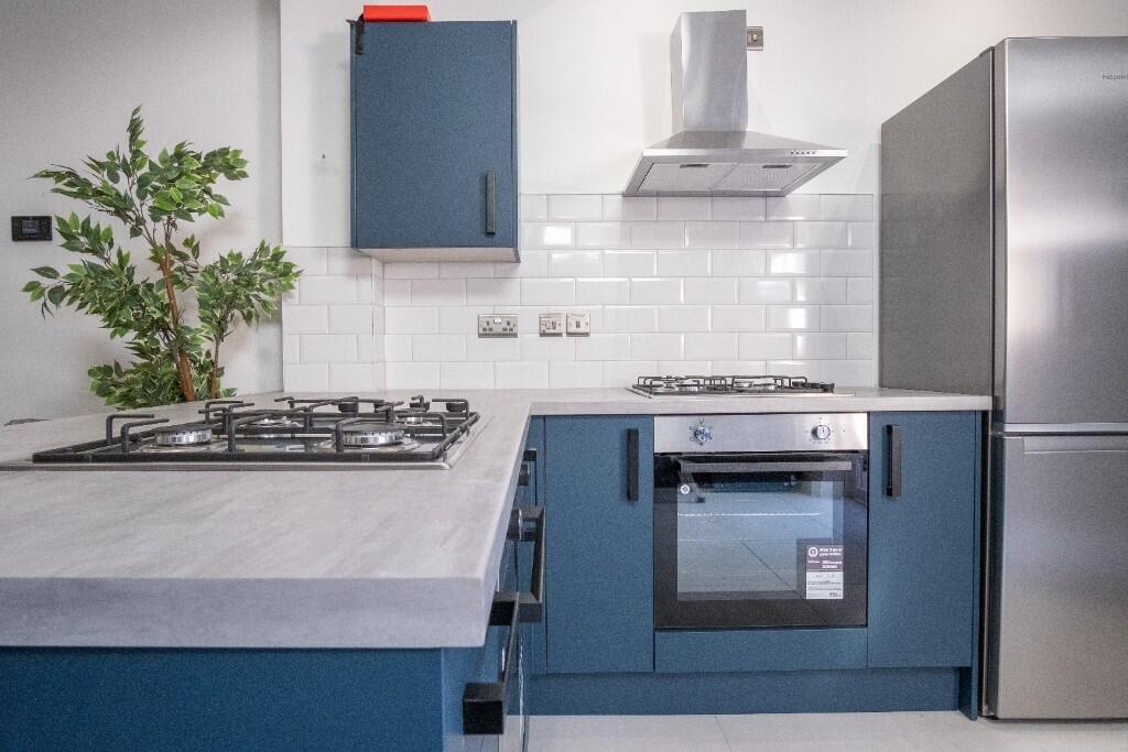 Contemporary kitchen featuring blue cabinets, a...