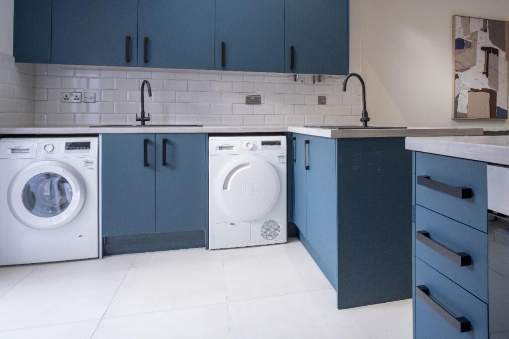 Bright, modern utility room with matching blue ...
