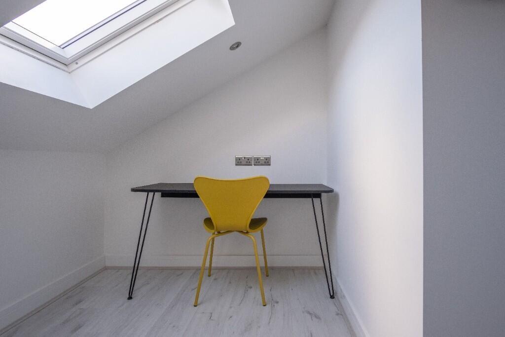Bright, minimalist workspace under a skylight w...