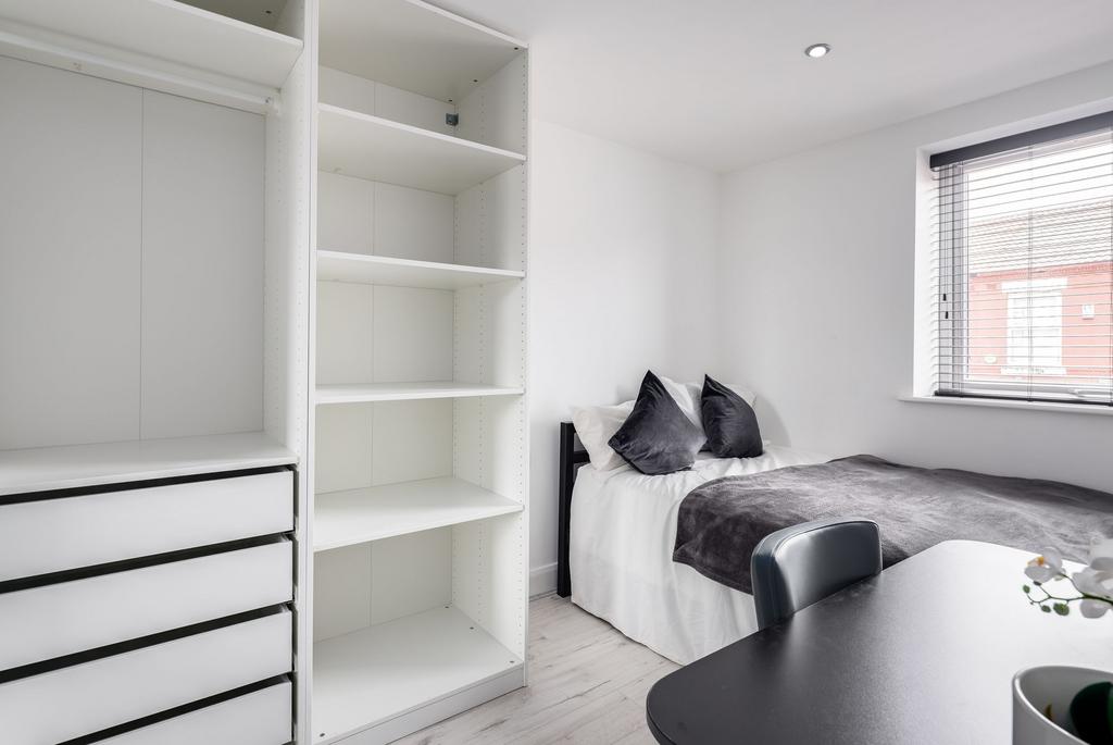 Bright and modern bedroom featuring a neatly ma...