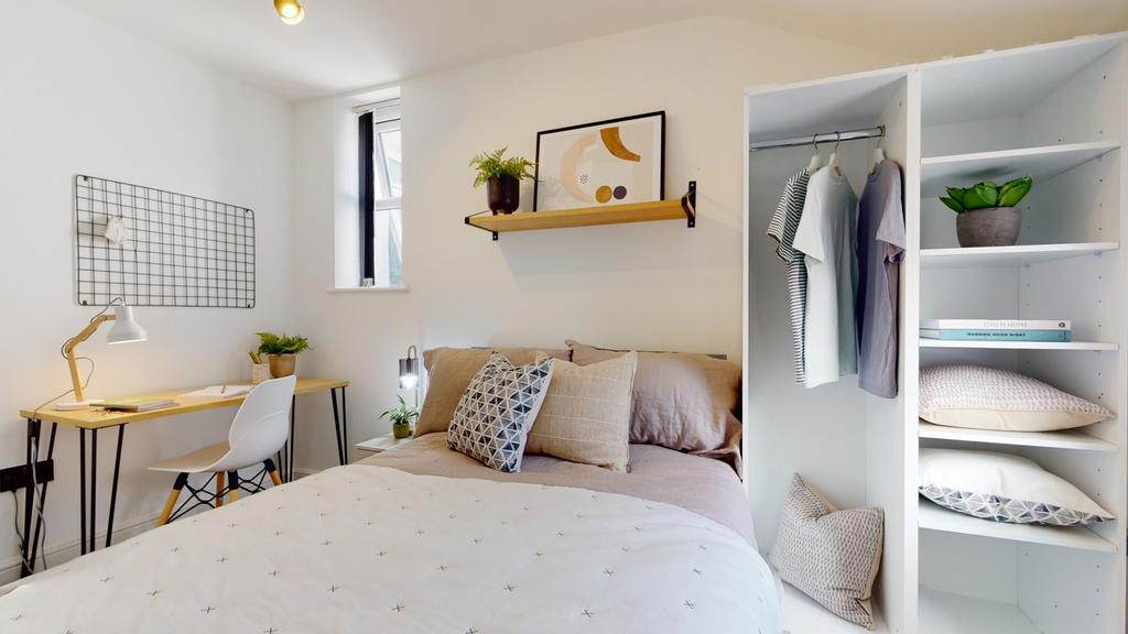 A bright and cozy double bedroom featuring mode...