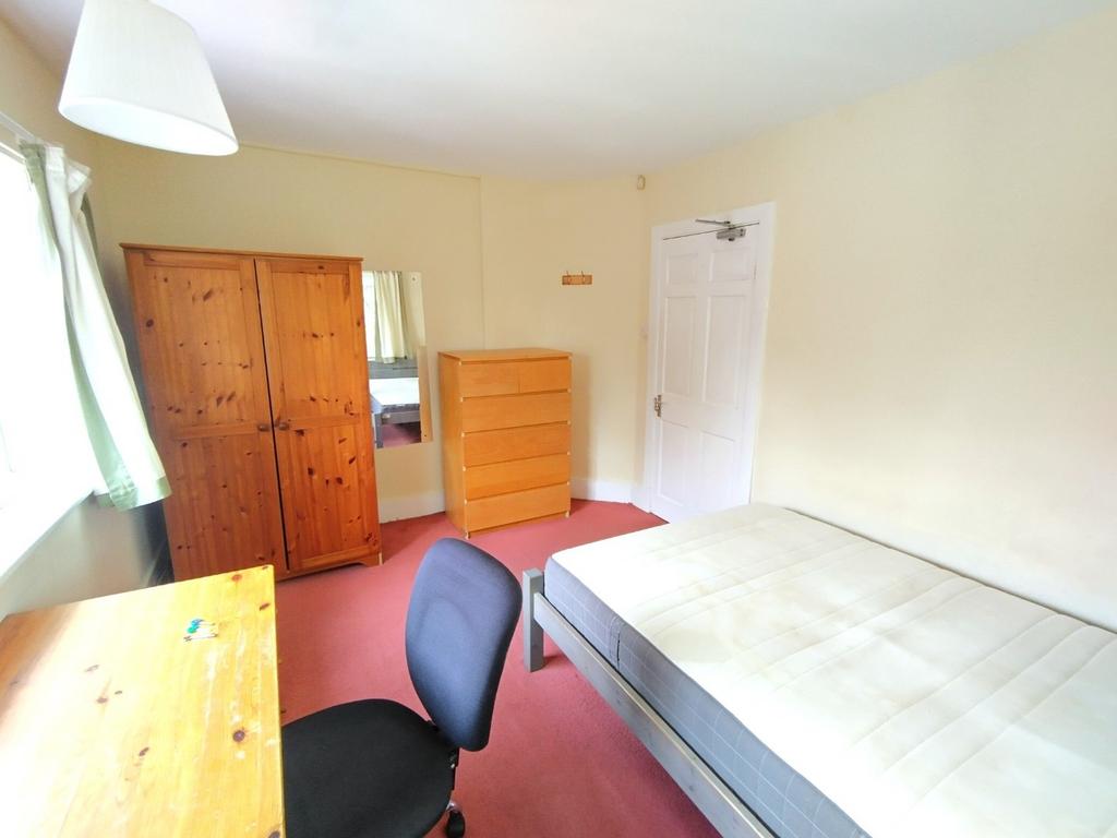 Bright, simply furnished bedroom with a single ...