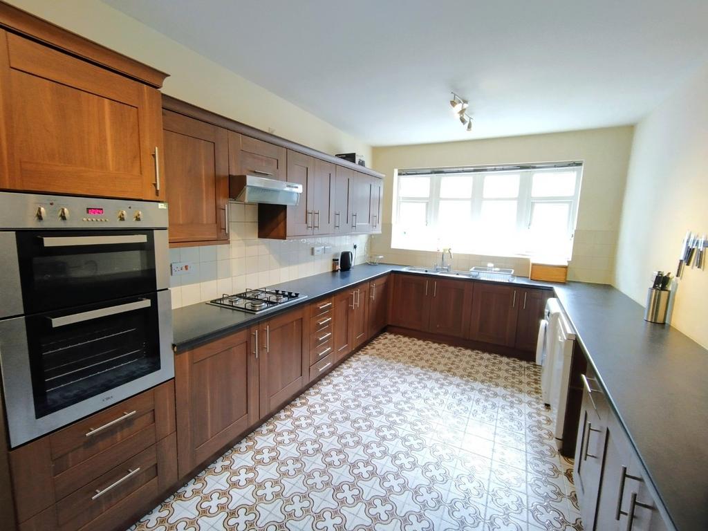 Bright, long galley kitchen with dark worktops,...