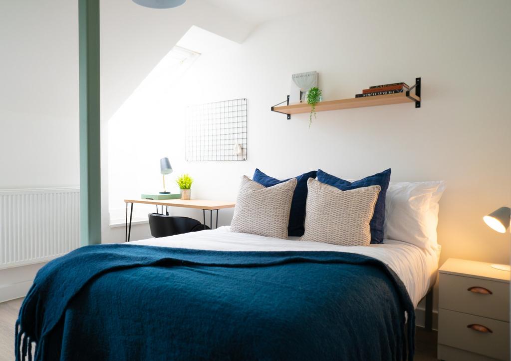 A bright and inviting double bedroom with styli...