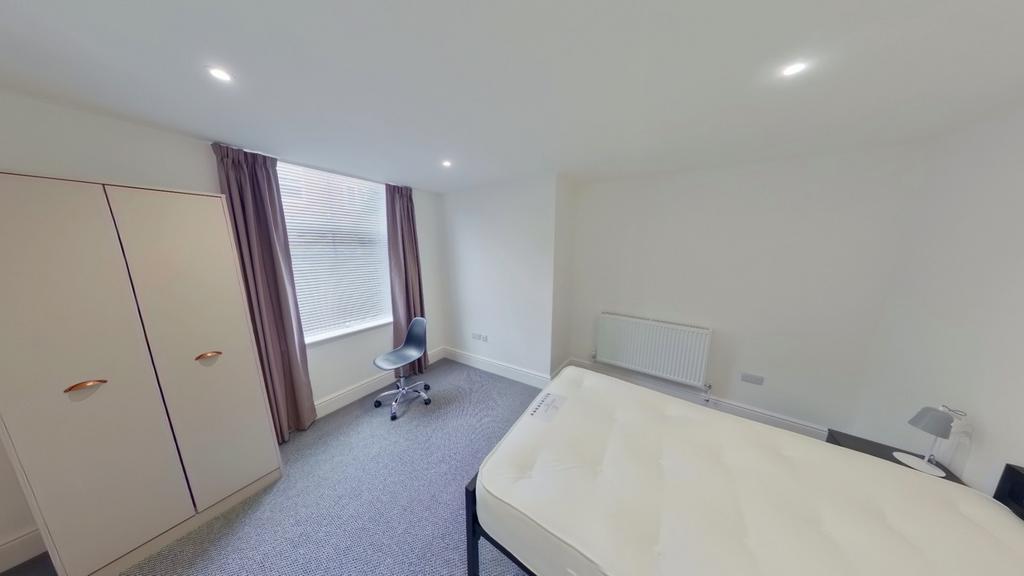A spacious and well-lit double bedroom featurin...
